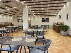 a restaurant with tables and chairs in a room at Villa Demetra Resort in San Leone