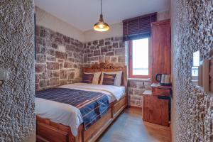 a bedroom with a bed and a stone wall at Kilitbahir Kale Konak in Eceabat