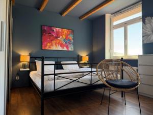 a bedroom with a bed and a chair and a painting at Maiers Hotel in Bayerisch Eisenstein