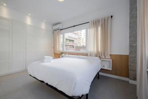 a bedroom with a large white bed and a window at Plata by Clabao in Madrid +25 photos