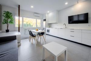 a kitchen with white cabinets and a white table at Plata by Clabao in Madrid