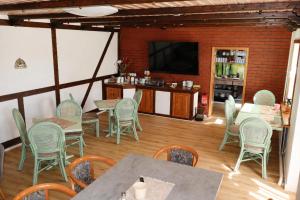 a dining room with tables and chairs and a television at Möwennest Zempin in Zempin