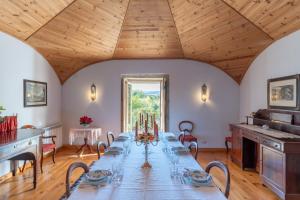 a long table in a room with a wooden ceiling at Feel Discovery Casa de Vilarinho de São Romão in Sabrosa
