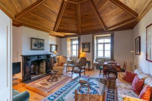 a living room with a fireplace and wooden ceilings at Feel Discovery Casa de Vilarinho de São Romão in Sabrosa