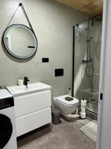 a bathroom with a toilet and a sink and a mirror at Sunset hausbot in Bratislava +39 photos