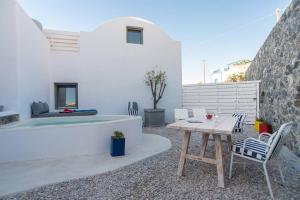 a patio with a table and chairs and a bed at Lagadi Suites Mesaria in Mesaria