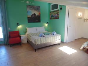a bedroom with a bed and a red chair at B&B Oasi al Mare in Agropoli