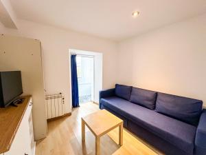 a living room with a blue couch and a table at Casa das Faluchas by ALÔGA in Finisterre
