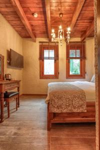 a bedroom with a bed and a desk and windows at Kilitbahir Kale Konak in Eceabat