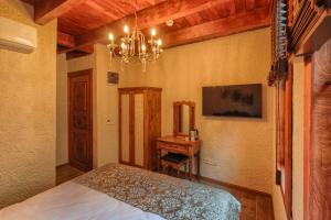 a bedroom with a bed and a table and a chandelier at Kilitbahir Kale Konak in Eceabat +62 photos