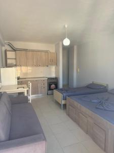 a living room with two beds and a kitchen at Shëngjin Beach Nest in Lezhë