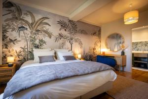 a bedroom with a large bed with a tropical wallpaper at Le Domaine Du Clos in Tourmont