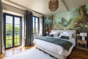 a bedroom with a large bed with a painting on the wall at Le Domaine Du Clos in Tourmont