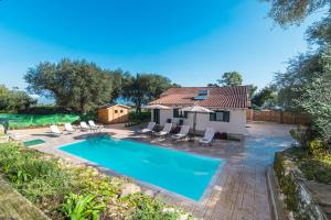 a swimming pool in front of a house at Villa Taxiarchis by Corfuescapes in Benitses