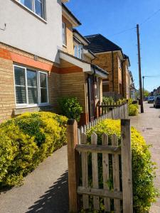 a wooden fence in front of a house at Greenhithe Guest House in Stonewood