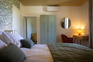 a bedroom with a bed and a mirror on the wall at Le Domaine Du Clos in Tourmont