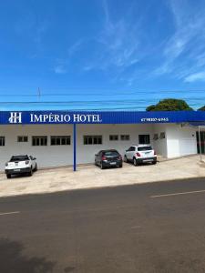 two cars parked in front of a hotel at Império Hotel in Costa Rica