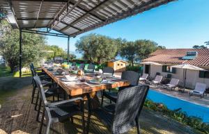 a wooden table and chairs under a pergola at Villa Taxiarchis by Corfuescapes in Benitses