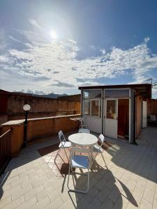 a patio with a table and chairs on a roof at Etna Terrace Casa Lidia in Gaggi