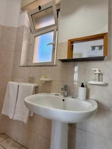 a bathroom with a white sink and a mirror at Etna Terrace Casa Lidia in Gaggi +16 photos