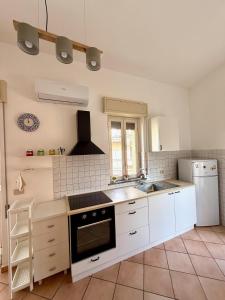 a kitchen with a sink and a stove top oven at Etna Terrace Casa Lidia in Gaggi
