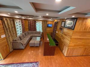 a large living room with a couch and a tv at Hotel The Apple Estate in Pahalgām +5 photos