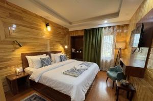 a hotel room with a bed and a desk and a bed sidx sidx sidx at Hotel The Apple Estate in Pahalgām