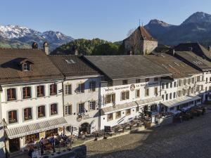 a group of buildings in a town with mountains at Le Saint Georges in Gruyères