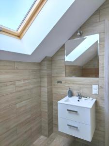 a bathroom with a white sink and a skylight at Domki i Apartamenty WiR na Kaszubach in Chmielno +66 photos