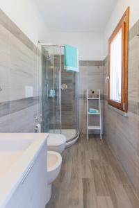 a bathroom with a toilet and a glass shower at Casa Martina by ElbaSummer in Lacona +34 photos