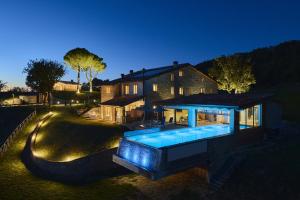 a house with a swimming pool in front of a house at Aura Relais in Urbino