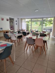 a classroom with tables and chairs and windows at Chez Swan et Yuliya in Mooslargue