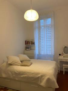 a bedroom with a bed with a window and a light at Passage Foch centre historique in Perpignan