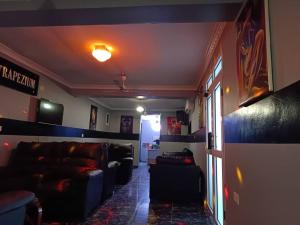 a living room with leather couches in a room at Trapezium Lodge in Amasaman