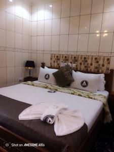 a bedroom with two beds with towels on them at Trapezium Lodge in Amasaman