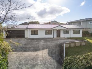 a white house with a driveway in front of it at Welcome Bay Stay in Tauranga