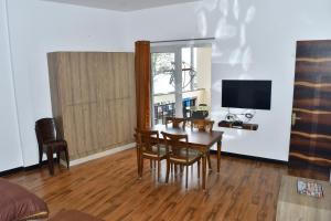 a living room with a table and chairs and a television at Zeeenu Abode Yercaud by GD in Yercaud