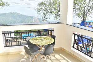 a dining room with a table and chairs and windows at Zeeenu Abode Yercaud by GD in Yercaud