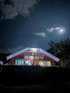 a brick building at night with the moon in the sky at Mistvale Cottage in Manāli +5 photos