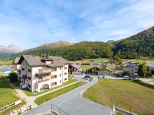 Luftaufnahme eines Hauses mit Bergen im Hintergrund in der Unterkunft Hotel Allegra in Zuoz