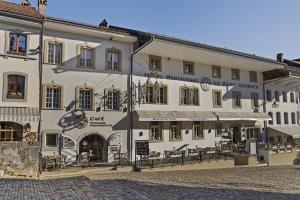 a large white building with tables and chairs in front of it at Le Saint Georges in Gruyères +120 photos