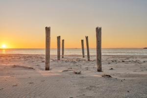 a group of posts in the sand on a beach at Blacksmith's Cottage at Lisdillon Estate in Little Swanport