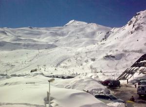 a snow covered mountain with cars parked on it at Studio 4 pers pieds des pistes Piau-engaly in Aragnouet