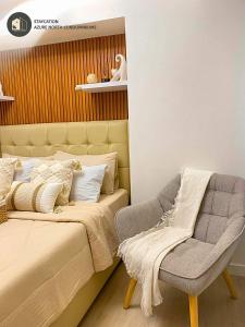 ein Schlafzimmer mit einem Bett und einem Stuhl daneben in der Unterkunft Beigetopia in Sampong