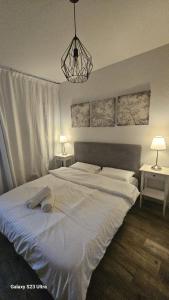 a bedroom with a large white bed with two tables at Rona Suite in Caesarea