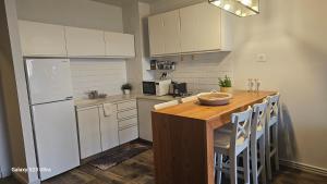 a kitchen with a white refrigerator and a wooden table at Rona Suite in Caesarea