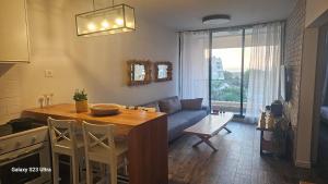 a kitchen and living room with a table and a couch at Rona Suite in Caesarea +4 photos