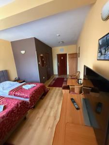 a room with a bed and a desk with a television at Hotel Grodzki in Sandomierz +20 photos