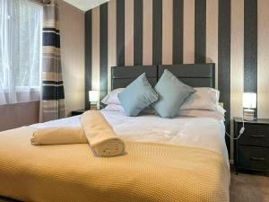a bedroom with a bed with a yellow blanket on it at The Ash in Angus +2 photos