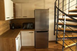 a kitchen with a stainless steel refrigerator and a spiral staircase at Apartmán Říčky 23 in Říčky
